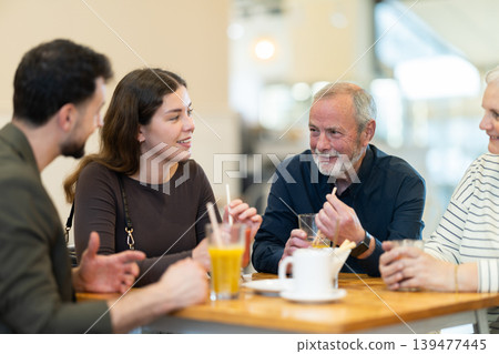 Family day. Multiage family drink coffee or juice in restaurant Family day. Multiage family drink coffee or juice in restaurant 139477445