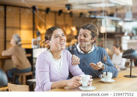 Cheerful man and woman enjoying date in cozy cafe Cheerful man and woman enjoying date in cozy cafe 139477552