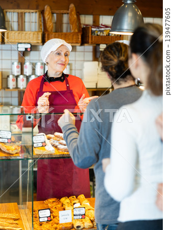 People place order at bakery, buy sweet pastries in cafeteria, senior woman worker serving people 139477605