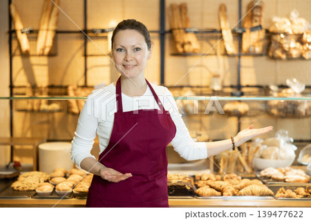 Female baker confidently welcoming customers into her bakery Female baker confidently welcoming customers into her bakery 139477622