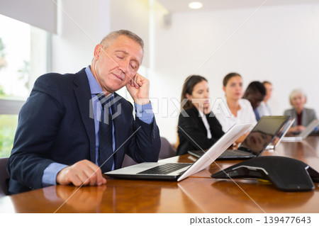 Man in suit sleeping during conference Man in suit sleeping during conference 139477643