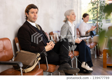 Adult man in suit sitting on chair in the office 139477789
