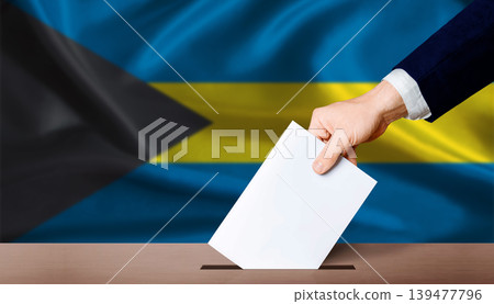 Hand placing a ballot in ballot box with the Bahamian flag in the background. Bahamas Parliamentary vote Hand placing a ballot in ballot box with the Bahamian flag in the background. Bahamas Parliamentary vote 139477796