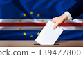 Cape Verde Parliamentary vote 2026. Hand placing a ballot in ballot box with the Cape Verdean flag in the background 139477800