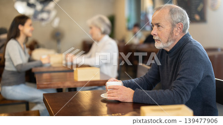 Elderly man with hot cup of coffee in hands 139477906