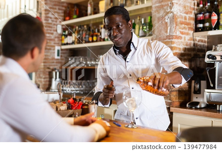 Professional bartender prepares cocktail for restaurant guests Professional bartender prepares cocktail for restaurant guests 139477984