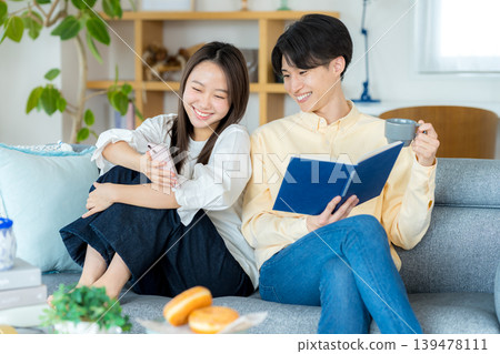 年輕夫婦在客廳裡看智能手機 139478111