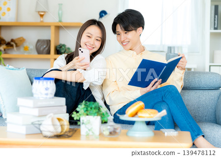 Young couple looking at a smartphone in the living room 139478112