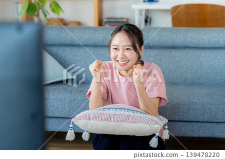 一位年輕的女士在客廳裡看電視 139478220