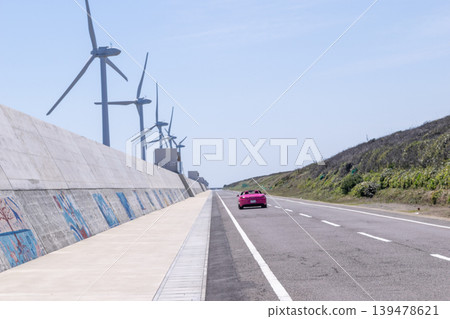 沿海一條筆直的道路,兩旁林立著風車。 沿海一條筆直的道路,兩旁林立著風車。 139478621