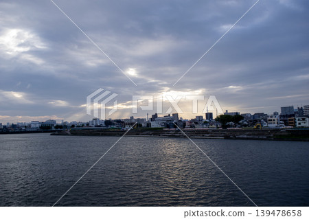 The riverside townscape bathed in the lingering light of the setting sun. The riverside townscape bathed in the lingering light of the setting sun. 139478658
