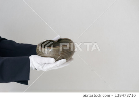 A person who appraises ceramics A person who appraises ceramics 139478710
