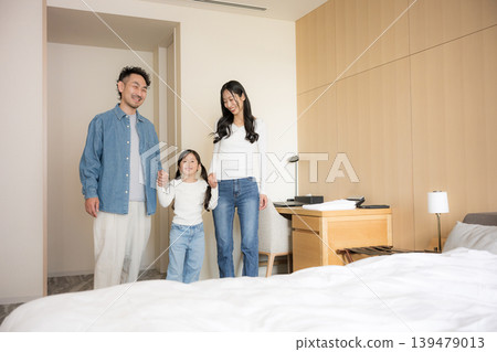 A happy family of three, smiling and having fun, enjoying a family trip to a hotel. A happy family of three, smiling and having fun, enjoying a family trip to a hotel. 139479013