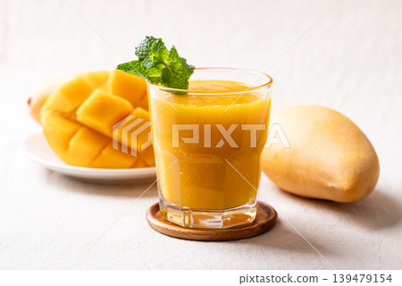 Fresh mango smoothie in a glass with ripe mango slices  139479154