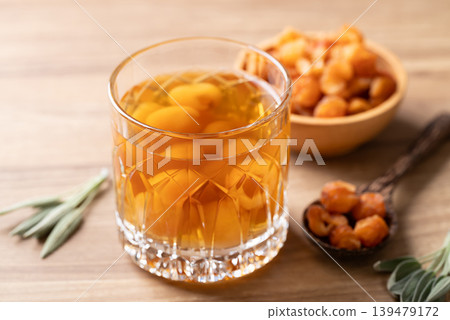 Longan juice in glass with dried longan fruit on wooden background Longan juice in glass with dried longan fruit on wooden background 139479172