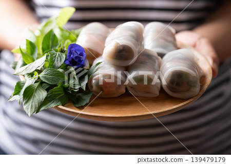 Thai Fresh Spring Rolls with Herbs and Vegetables holding by woman hand Thai Fresh Spring Rolls with Herbs and Vegetables holding by woman hand 139479179