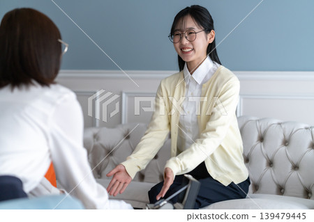 一位女顧客認真地聽著上門進行現場評估的估價師的講解。 一位女顧客認真地聽著上門進行現場評估的估價師的講解。 139479445
