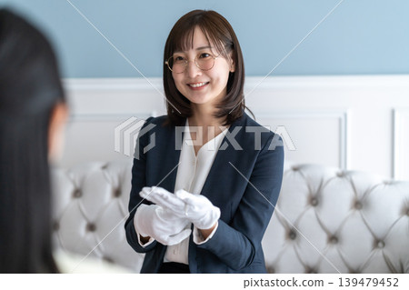 Title candidate: A female appraiser who smiles and politely explains the results of the watch appraisal. 139479452
