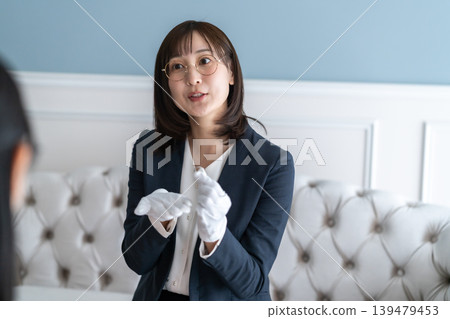 Title candidate: A female appraiser who smiles and politely explains the results of the watch appraisal. 139479453