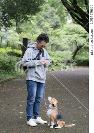 A man who owns a beagle, a smiling portrait of him walking his dog, a faceless image with eye contact that evokes images of training and discipline. A man who owns a beagle, a smiling portrait of him walking his dog, a faceless image with eye contact that evokes images of training and discipline. 139479695