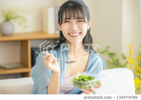 A young woman eating a salad A young woman eating a salad 139479766