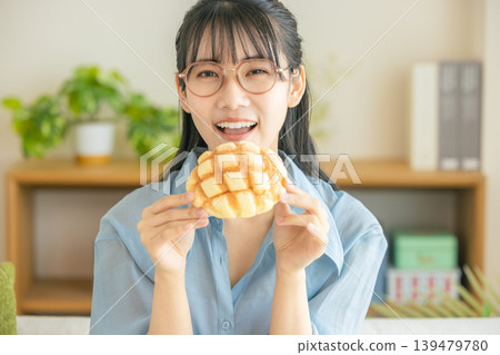A young woman eating melon bread A young woman eating melon bread 139479780