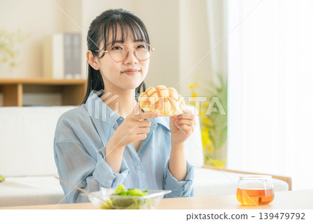 A young woman eating melon bread A young woman eating melon bread 139479792