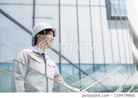 年輕男子的肖像,例如建築經理,戴著安全帽,在建築物的背景下仰望未來和希望;年輕男子的側影。 年輕男子的肖像,例如建築經理,戴著安全帽,在建築物的背景下仰望未來和希望;年輕男子的側影。 139479960