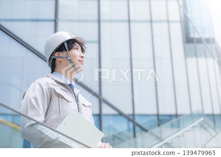 年輕男子的肖像,例如建築經理,戴著安全帽,在建築物的背景下仰望未來和希望;年輕男子的側影。 年輕男子的肖像,例如建築經理,戴著安全帽,在建築物的背景下仰望未來和希望;年輕男子的側影。 139479965