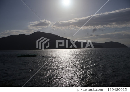 陽光灑在琵琶湖上,湖面泛著潔白的光芒,遠處是輪廓分明的山脈、朵朵白雲和蔚藍的天空。 陽光灑在琵琶湖上,湖面泛著潔白的光芒,遠處是輪廓分明的山脈、朵朵白雲和蔚藍的天空。 139480015