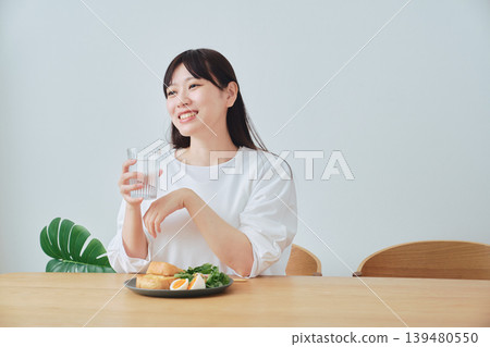 A woman listening to a conversation while having breakfast A woman listening to a conversation while having breakfast 139480550
