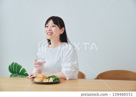 A woman listening to a conversation while having breakfast A woman listening to a conversation while having breakfast 139480551