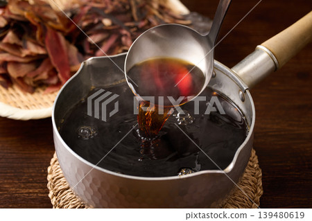 Scoop the soba dipping sauce with a ladle. Scoop the soba dipping sauce with a ladle. 139480619