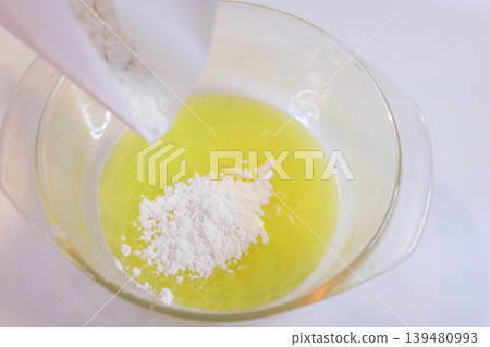 Making choux pastry by mixing melted butter and flour. Making choux pastry by mixing melted butter and flour. 139480993