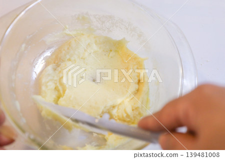 Making choux pastry by mixing melted butter and flour. Making choux pastry by mixing melted butter and flour. 139481008