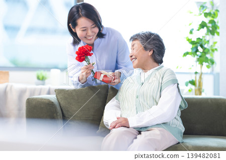 Mother's Day: Senior women receive carnations and gifts. 139482081