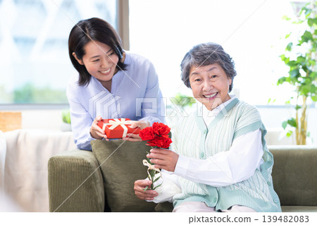 Mother's Day: Senior women receive carnations and gifts. Mother's Day: Senior women receive carnations and gifts. 139482083