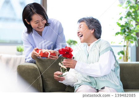 Mother's Day: Senior women receive carnations and gifts. Mother's Day: Senior women receive carnations and gifts. 139482085
