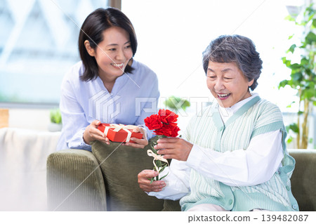 Mother's Day: Senior women receive carnations and gifts. Mother's Day: Senior women receive carnations and gifts. 139482087