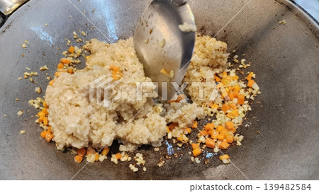 Cooking Vegetable Fried Rice in a Wok with Garlic and Carrots 139482584