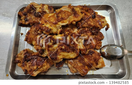 Fried Boneless Chicken Thighs with Golden Crispy Skin on a Stainless Steel Tray 139482585