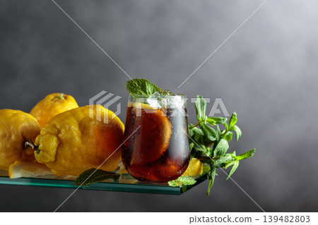 Cocktail with lemon wedges, ice and mint in misted glass. Cocktail with lemon wedges, ice and mint in misted glass. 139482803