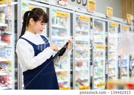 Woman using a tablet in a supermarket Woman using a tablet in a supermarket 139482815
