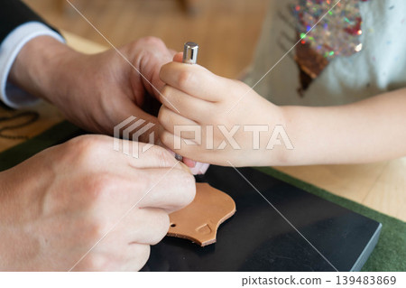 A photo of a child stamping leather. 139483869