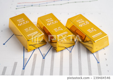 Gold bars on graph paper, finance trading investment business currency. Gold bars on graph paper, finance trading investment business currency. 139484546