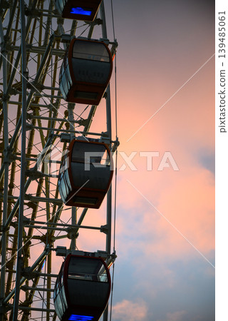 Ferris wheel gondolas against pink sunset sky Ferris wheel gondolas against pink sunset sky 139485061