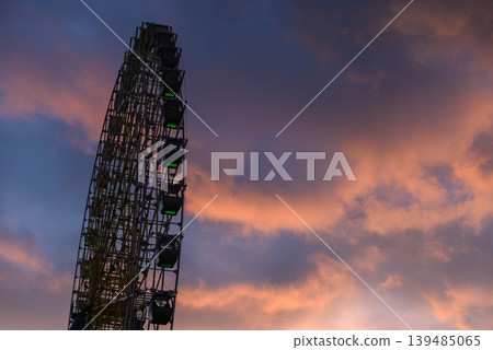 Ferris wheel silhouette at sunset with colorful clouds Ferris wheel silhouette at sunset with colorful clouds 139485065