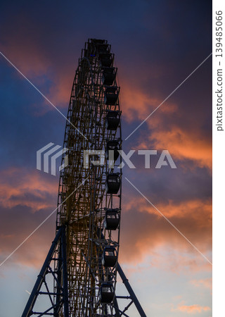 Ferris wheel silhouette at sunset with dramatic clouds 139485066