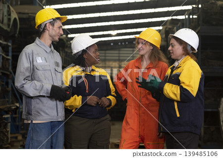 Group worker factory or engineer men and women standing with confidence and success. People discussing in workplace of warehouse industrial factory. Group worker factory or engineer men and women standing with confidence and success. People discussing in workplace of warehouse industrial factory. 139485106