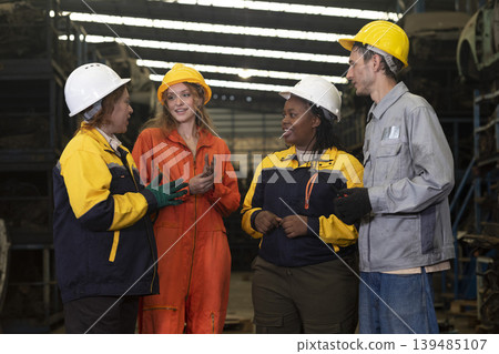 Group worker factory or engineer men and women standing with confidence and success. People discussing in workplace of warehouse industrial factory.  139485107